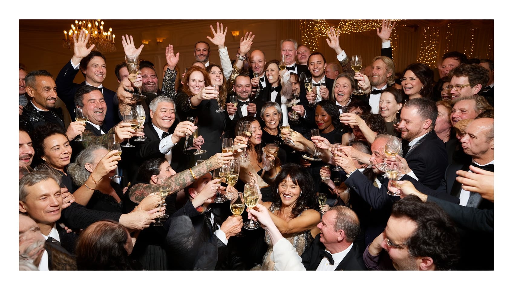 Guests in formal attire toasting together at an elegant black tie gala