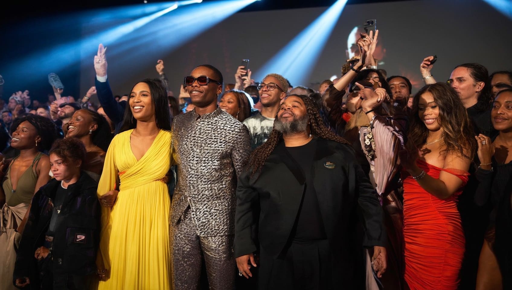 Guests celebrating together under stage lights at a premiere night event
